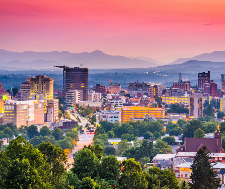 Small business owner reviewing Asheville disaster recovery grant application following Tropical Storm Helene damage, representing the city's $15.5 million small business support program.